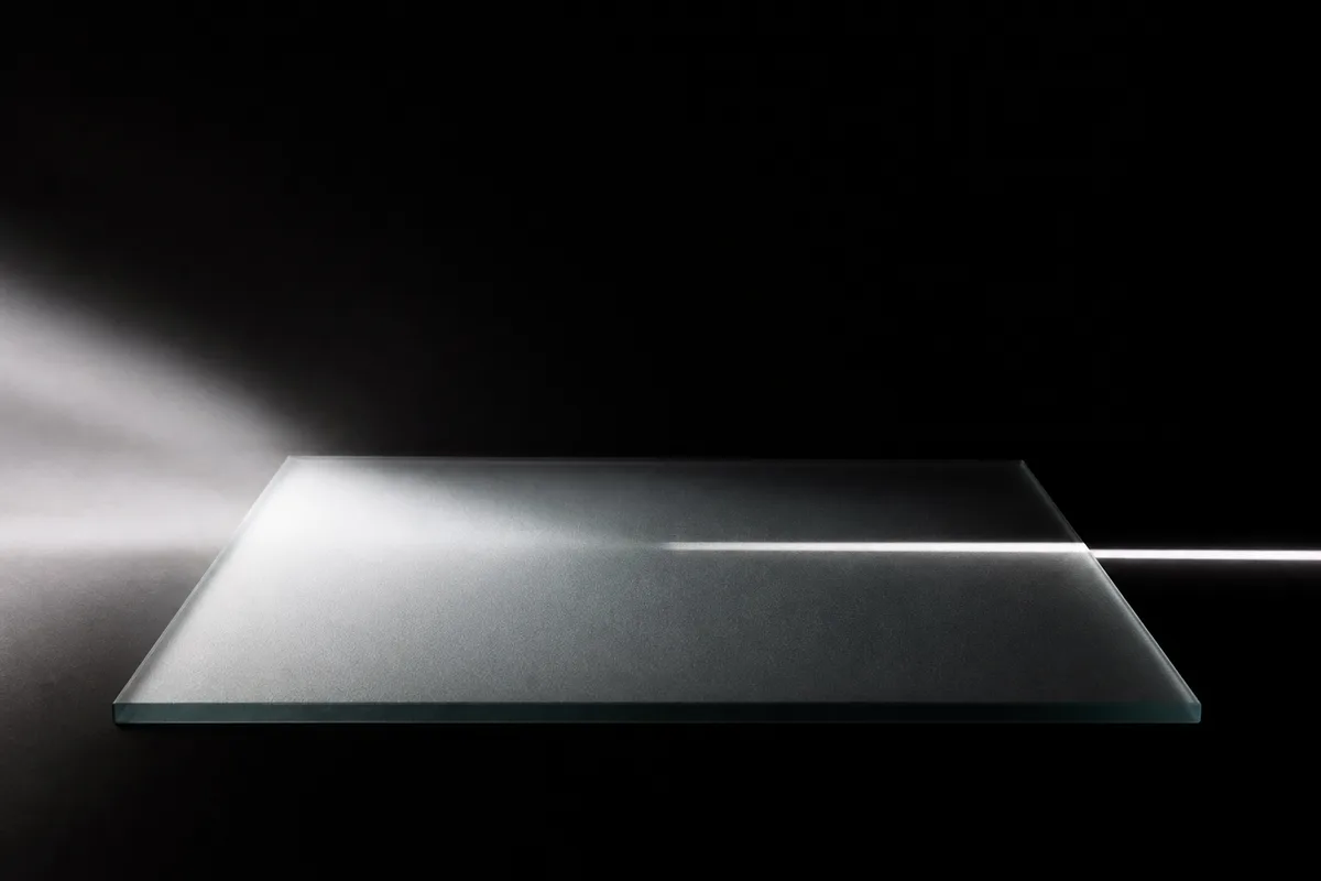 Faisceau lumineux traversant une pièce sombre au-dessus d’une surface lisse